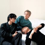 Members of South Korean indie rock band wave to earth.