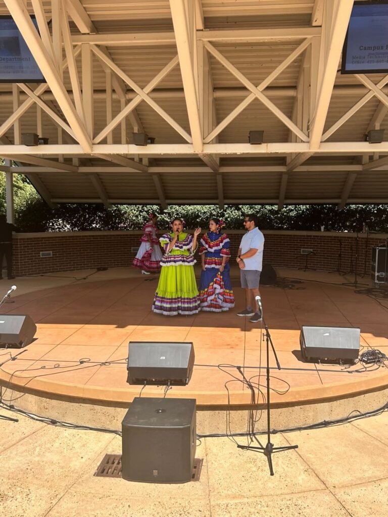 Two dancers in traditional Mexican attire perform on the outdoor amphitheater stage during Latin Fest.